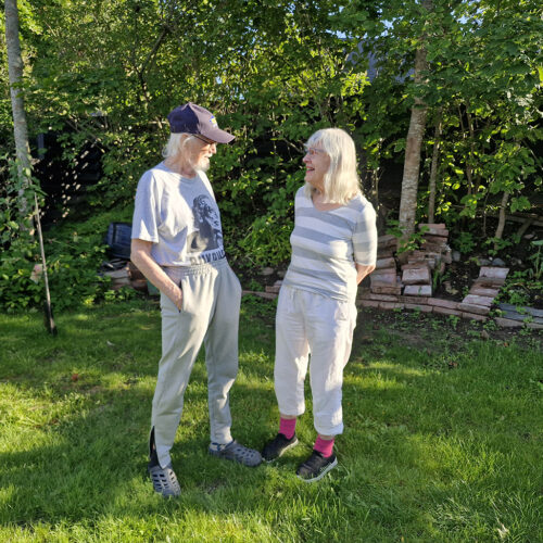 Aarre Kärkkäinen ja Hilkka Okkonen yhteiskuvassa seisomassa vierekkäin vihreässä puutarhassa kasvokkain