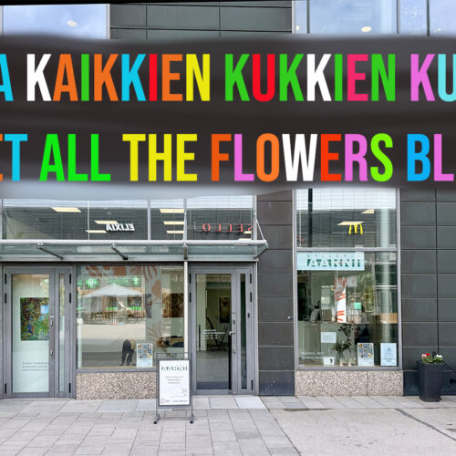 galleria kuvattuna ulkopäin, yläosassa värikäs teksti Anna Kaikkien Kukkien Kukkia Let All The Flowers Bloom